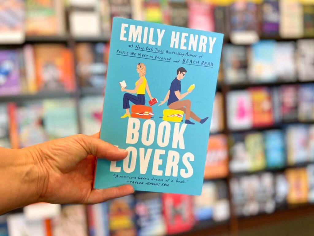 Book Lovers book club questions. By Emily Hendry. Hand holding book cover .