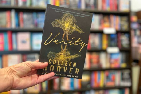 Verity book club questions, with hand holding the book cover .