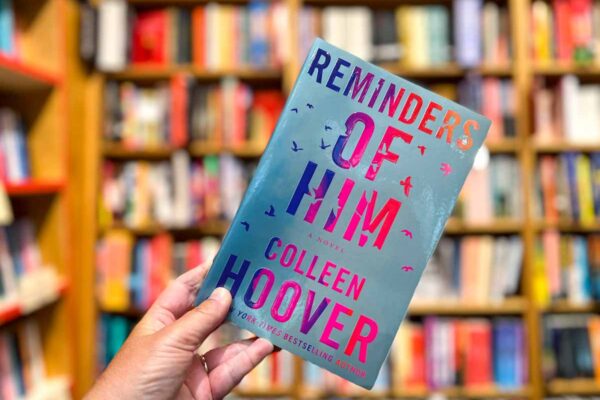 Reminders of Him book club questions, Colleen Hoover with book cover and shelves.